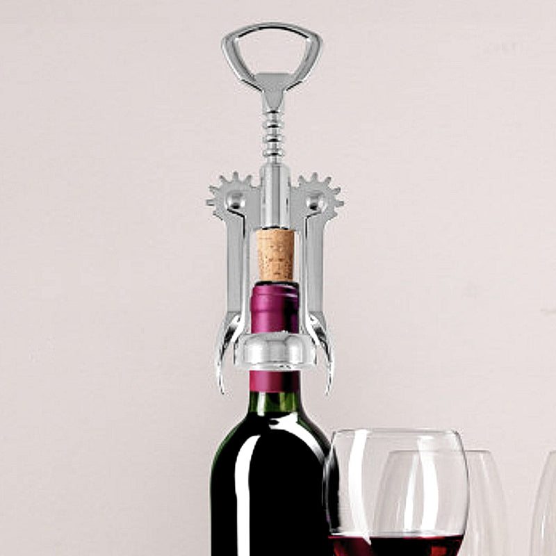 OGGI stainless steel winged corkscrew shown removing a cork from a wine bottle, with glass as a prop