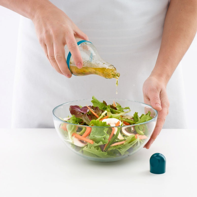Pouring dressing on salad with the Lékué shaker