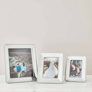 Nambé Braid Photo Frame in a display setting; other items shown are sold separately.