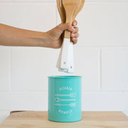 Now Designs turquoise metal utensil crock on countertop with utensils shown for scale