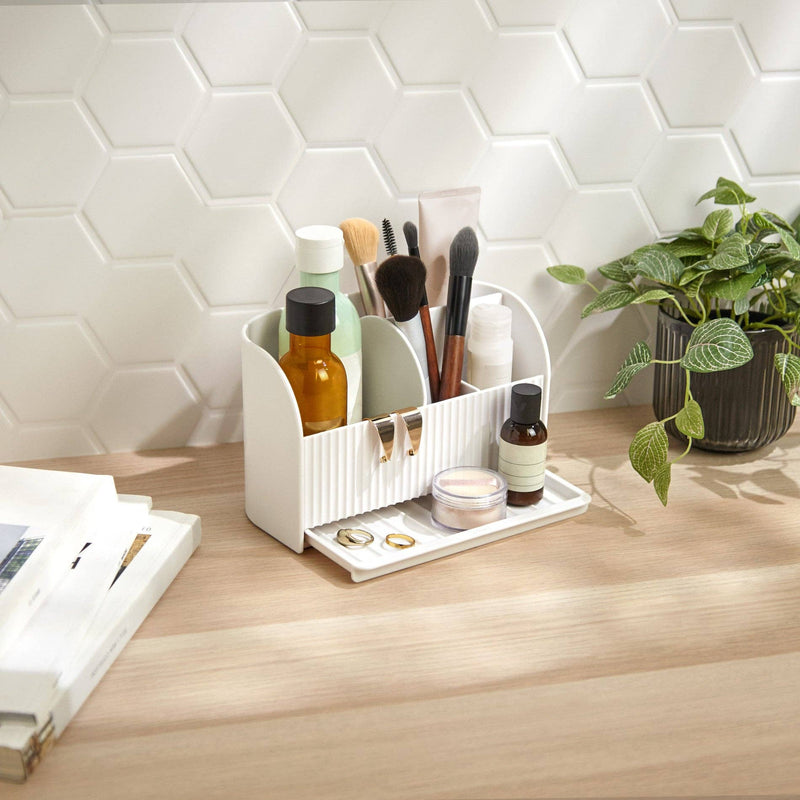 Umbra Stash organizer holding skincare and brushes on a bathroom counter